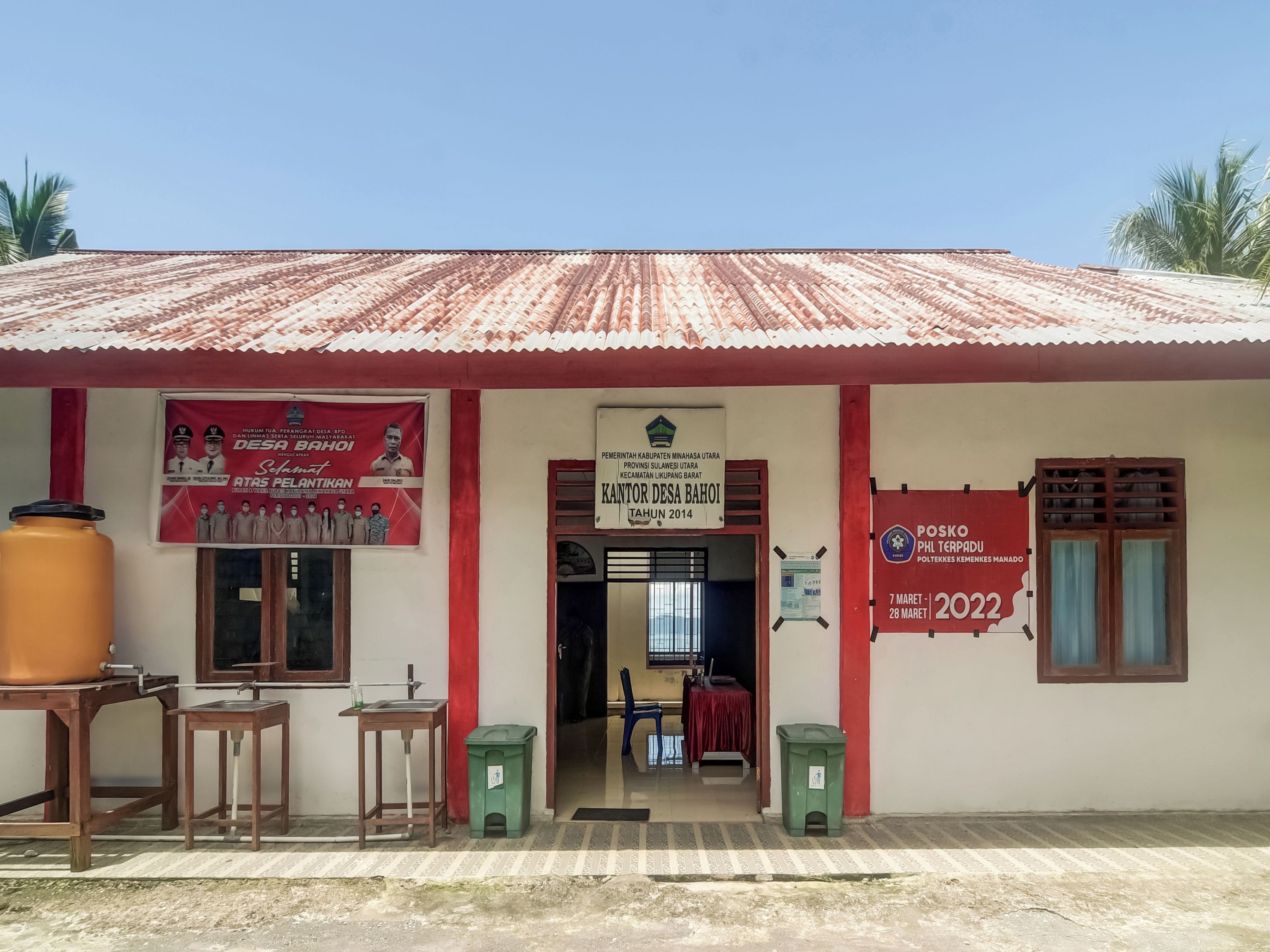 A building with a corrugated metal roof, a signboard, and a small entrance.