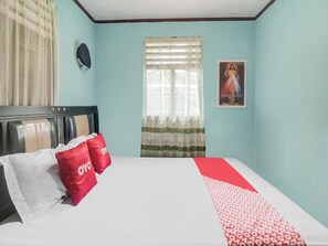 A bedroom with a bed, a window with curtains, a poster on the wall, and a headboard. - OYO Homes 91148 Homesstay Desa Wisata Bahoi (Bahoi)