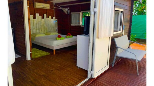 Un dormitorio con cama, televisor y sillón.