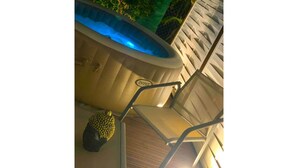 Un área de piscina con una silla y un jacuzzi.