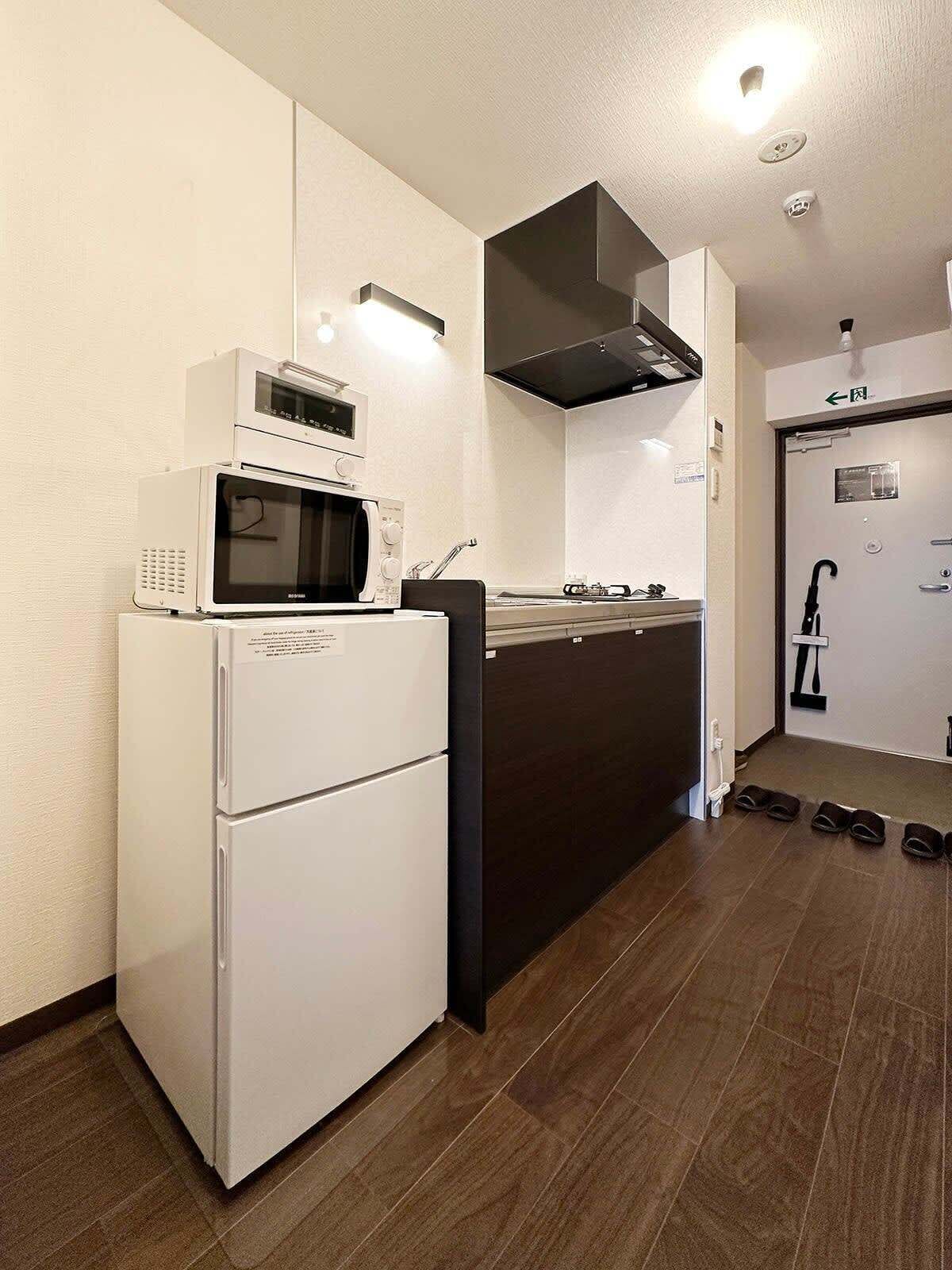 Kylskåp, mikrovågsugn, spishäll och grytor/köksredskap