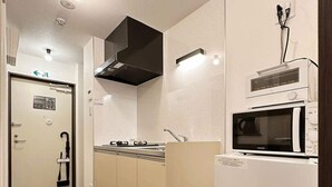 A compact kitchen with a microwave, stove, and sink.