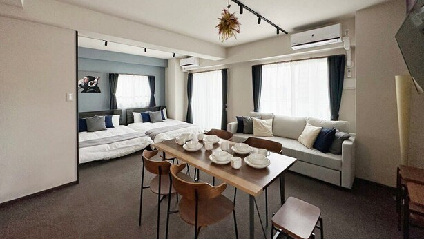 Ein modernes Hotelzimmer mit Essbereich, einer Couch und einem Bett.