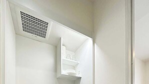 Una kitchenette compacta con microondas, estufa, lavabo y alacenas.