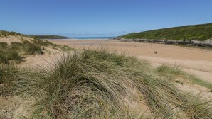 A beach with sand dunes and grassy areas. - Lavender House (Newquay)