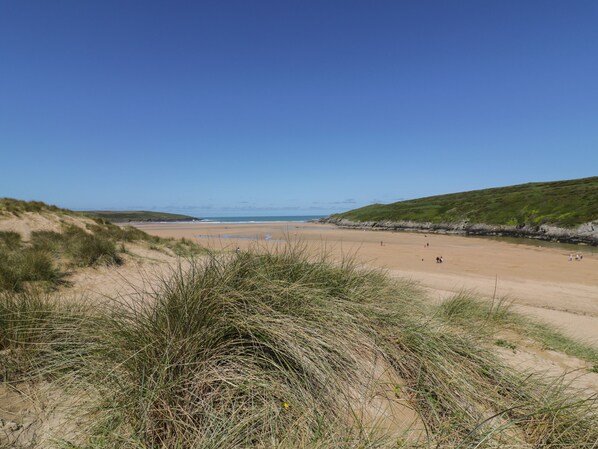 A beach with sand dunes and grassy areas. - Lavender House (Newquay)