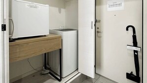 Une petite cuisine équipée comprenant un réfrigérateur, un petit évier et un four à micro-ondes.