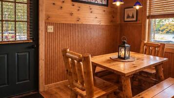 A wooden interior with a dining table, benches, and a star decoration on the wall.