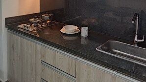 A modern kitchen with a microwave, stove, and sink. - BERILO DELUXE APARTAHOTEL (Barranquilla)