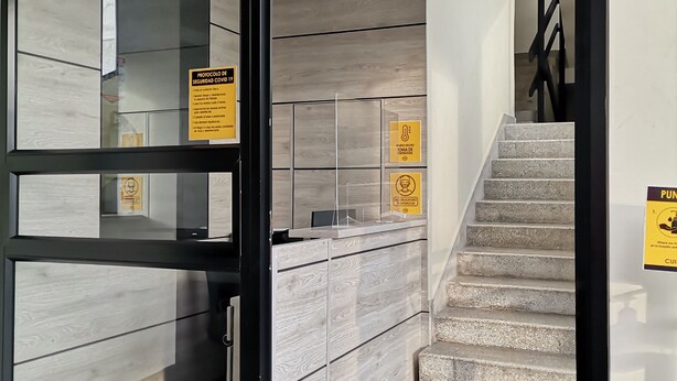 A hotel lobby with a reception desk, a staircase, and a tiled floor. - BERILO DELUXE APARTAHOTEL (Barranquilla)