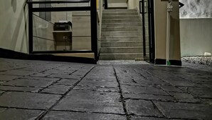 A hotel entrance with a tiled floor, a staircase, and signs indicating COVID-19 protocols. - BERILO DELUXE APARTAHOTEL (Barranquilla)