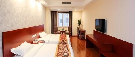 A hotel room with two beds, a TV, a desk, and a chair.