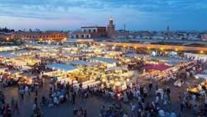 Un grand marché en plein air avec de nombreux étals et une foule de personnes.