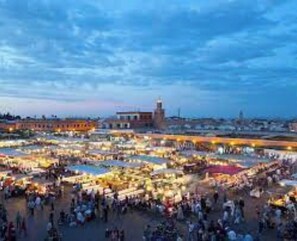 Un grand marché en plein air avec de nombreux étals et une foule de personnes.