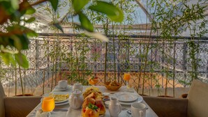 A table set for breakfast with various dishes, a pitcher, and a glass of orange juice. - Deluxe Room #8 (Marrakech)