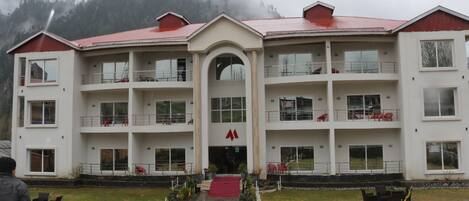 Stunning multi-story building with a central entrance, archway, and red roof, offering a beautiful view from the balconies.