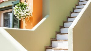 A staircase with white steps and a hanging flower basket. - Beautiful calm rooftop studio with stunning views (CHANIA)