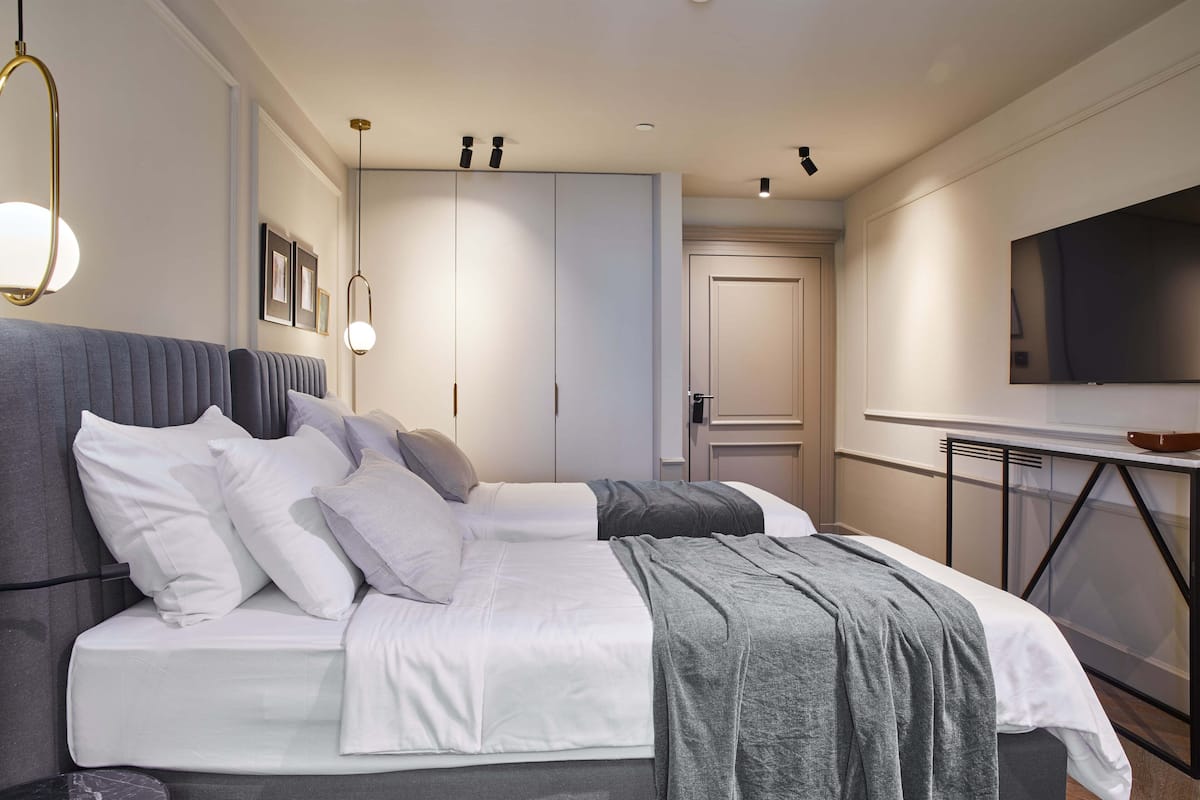 Une chambre moderne avec un grand lit, une télévision et une armoire.