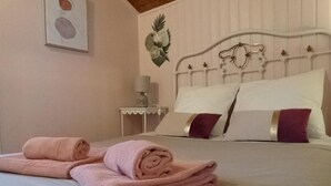 A neatly made bed with pink towels, a white headboard, and a small bedside table with a lamp. - Charming B&B for a sunny getaway with seasonal pool (VENTEROL)