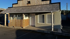 A small building with a wooden fence, a door, and a window.