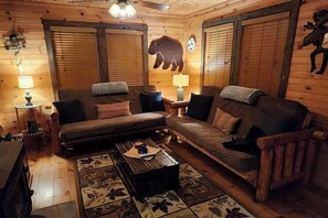 Ein gemütliches Blockhaus-Interieur mit einer Couch, einem Couchtisch und einer Lampe.