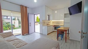 Una habitación de hotel moderna con una cama, una pequeña mesa de comedor y una kitchenette.