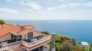 A coastal house with a terrace, a balcony, and a view of the sea. - Sunset House (Arco da Calheta)