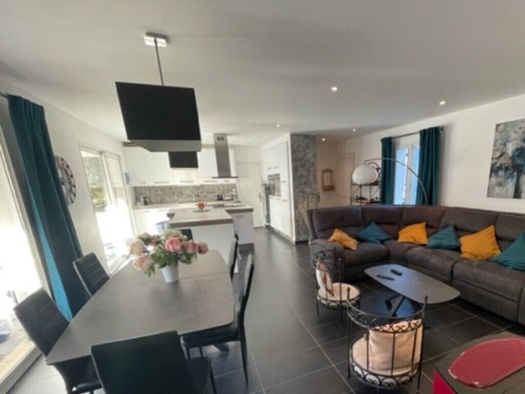 A modern living room with a sofa, coffee table, and dining area.