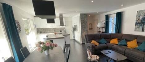 A modern living room with a sofa, coffee table, and dining area.