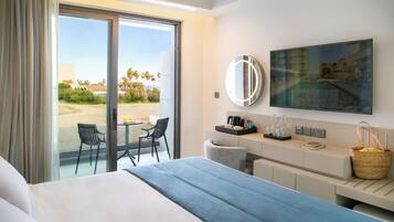 A hotel room with a bed, a desk, a chair, a TV, and a view of the outdoors.