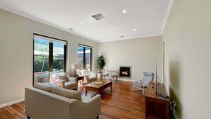 A spacious living room with a large sofa, a coffee table, and a fireplace.