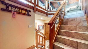 A wooden staircase with a metal handrail, a 'FAMILY' sign, and a 'MAMMOTTER ESTATE' parking permit on the wall. - Mammoth Estates #140 2 Bedroom Condo by RedAwning (Mammoth Lakes)