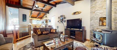 Un salón acogedor con chimenea, televisor y pared de piedra.