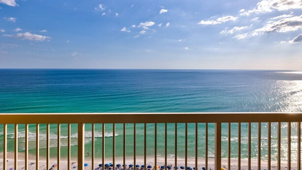 A beach view from a balcony with a railing, ocean, and clear sky. - Pelican Beach 1903 1 Bedroom Condo by Pelican Beach Management (Destin)