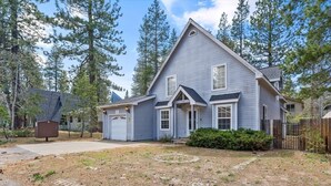 A single-story house with a gabled roof, a front garage, and a well-maintained lawn. - Sierra Mountain Lodge 3 Bedroom Home by RedAwning (South Lake Tahoe)
