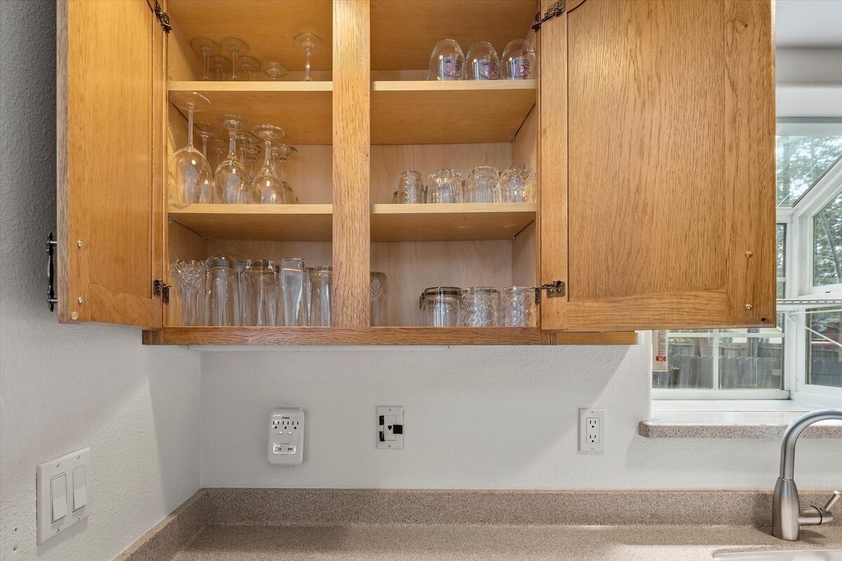 A kitchen with wooden cabinets, a countertop, and a window.