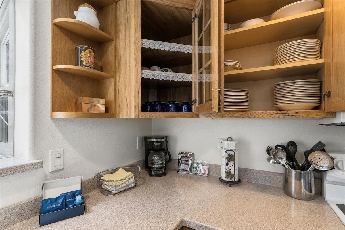 Une cuisine avec des meubles en bois, une machine à café et divers ustensiles de cuisine.