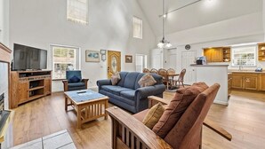 A spacious living room with a high ceiling, wooden furniture, and a television. - Sierra Mountain Lodge 3 Bedroom Home by RedAwning (South Lake Tahoe)