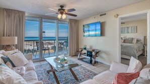 Una habitación de hotel con balcón, cama, televisor y mesa de centro.