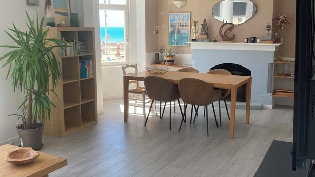 A modern living room with a dining area, a TV, and a view of the sea. - Duplex 5 persons seaside. (Wissant)