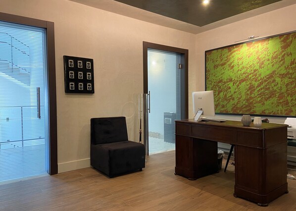 A modern office space with a desk, chair, and a large abstract painting on the wall.