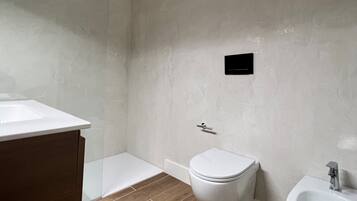 Ein modernes Badezimmer mit Toilette, Bidet und Waschbecken.