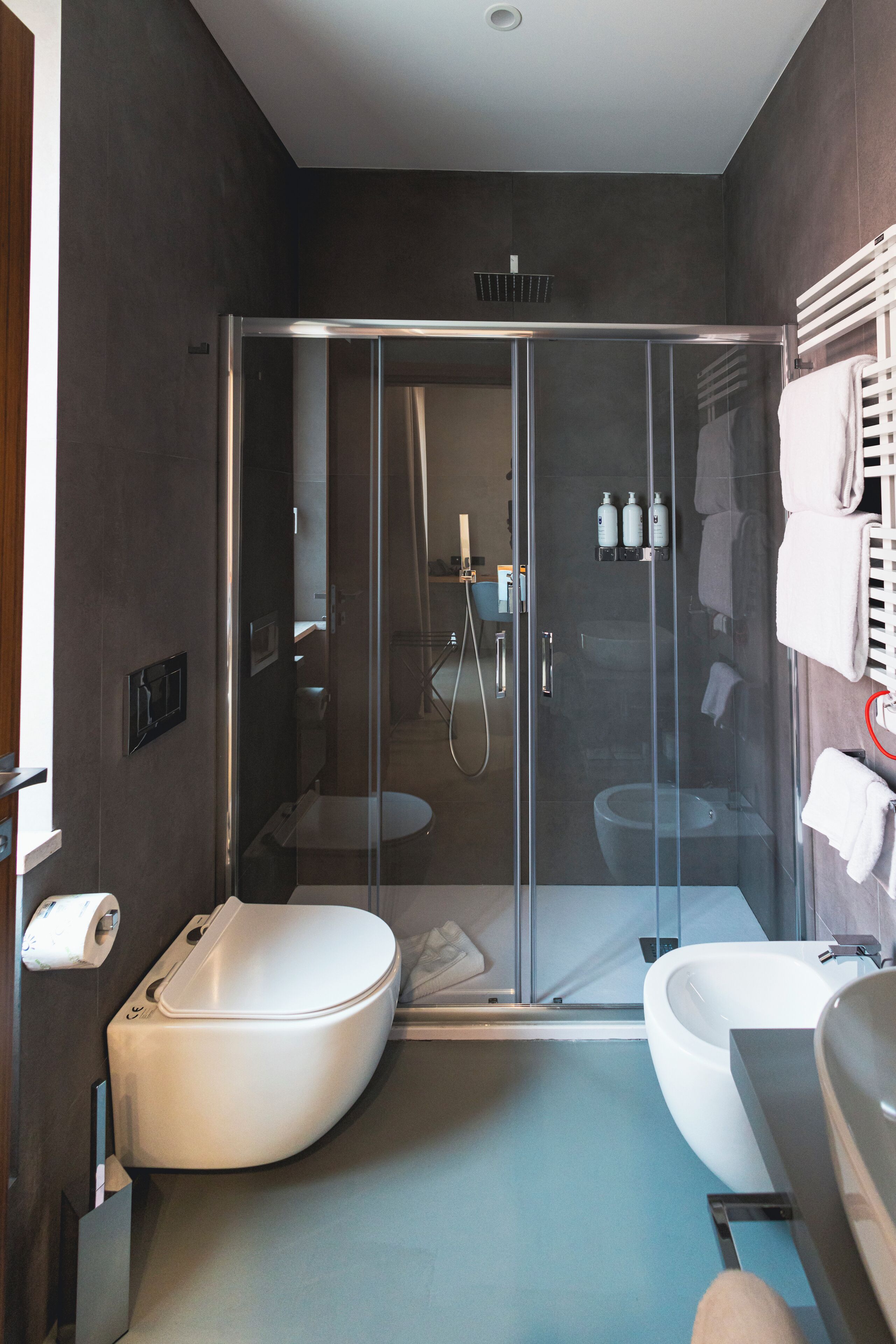 Ein modernes Badezimmer mit einer einteiligen Duschkabine, einer freistehenden Badewanne und einem separaten WC.