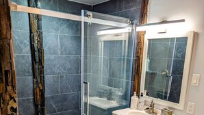 Une salle de bain moderne avec une douche à parois de verre, un lavabo blanc et des toilettes.