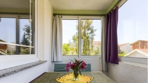A balcony with a table, chairs, and a vase of flowers. - Apartments Carpe Diem (Vir)