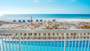 A poolside view with a beach and ocean in the background. - Pelican Beach 0206 1 Bedroom Condo by Pelican Beach Management (Destin)
