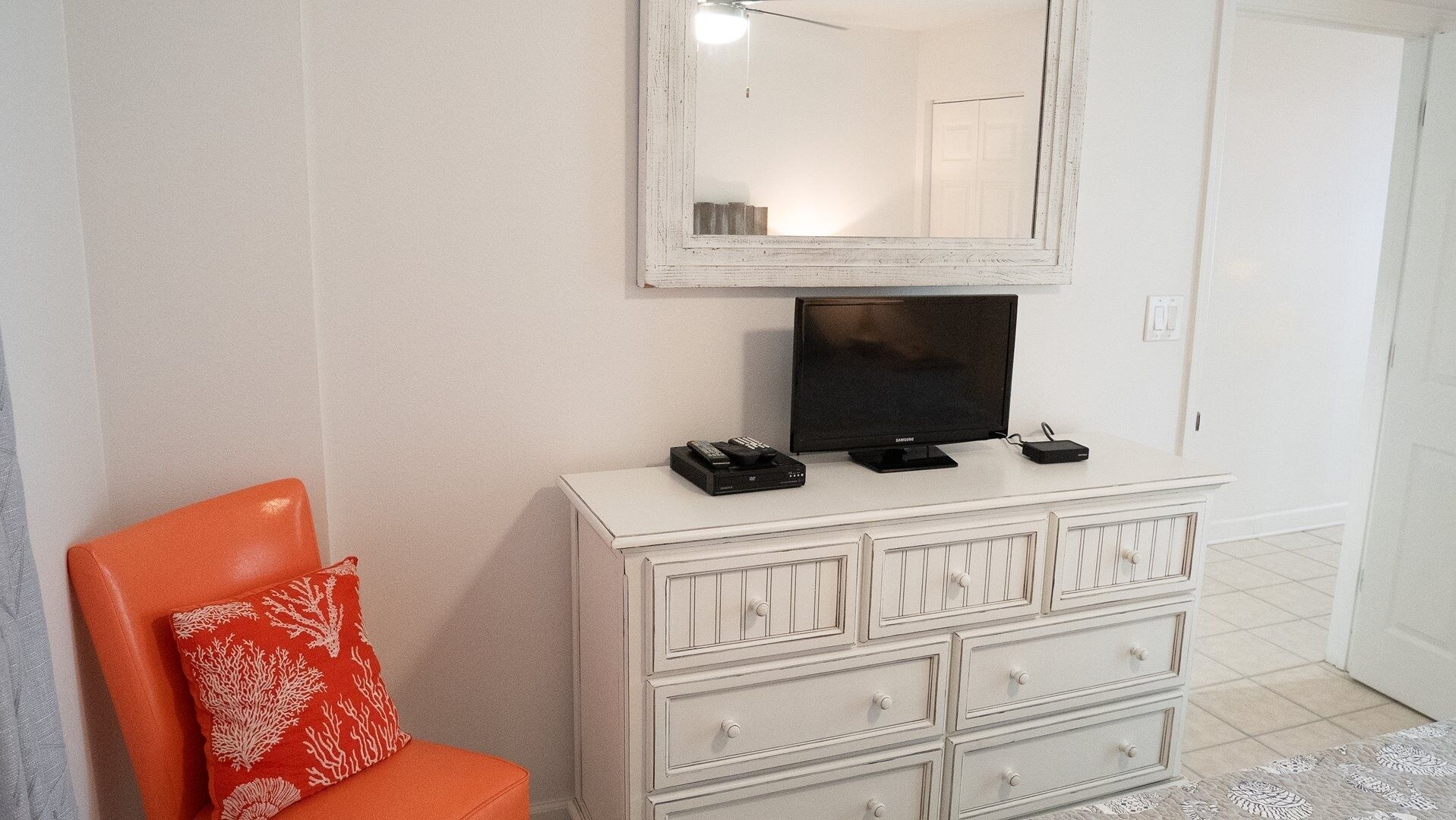 Een witte dressoir met een flatscreen televisie, een afstandsbediening en een USB-stick erboven.