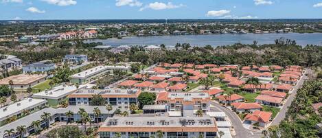 A residential area with a large building complex, a lake, and a bridge in the background.