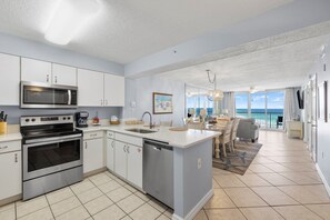 Enjoy ocean views from the kitchen and dining area, featuring a large island and stainless steel appliances.