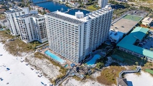 Un hotel moderno con numerosi balconi, una piscina e una spiaggia.